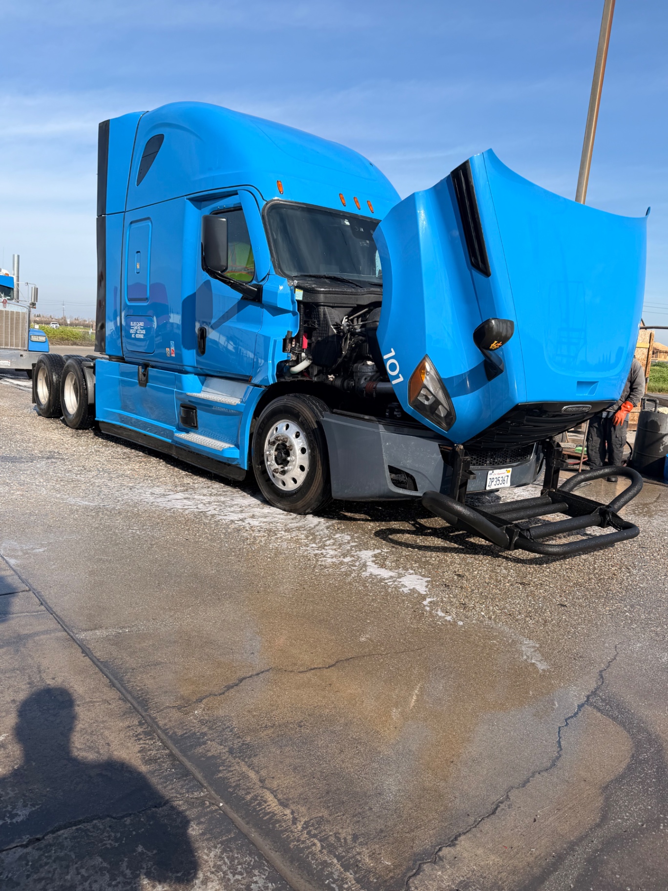 Blue Kenworth truck getting engine bay wash